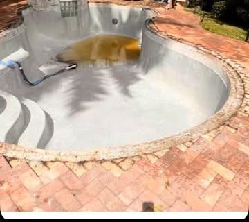 Pool deck before renovation, old brick pavers and drained pool
