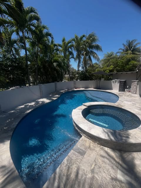 Travertine paver deck around freeform pool and spa