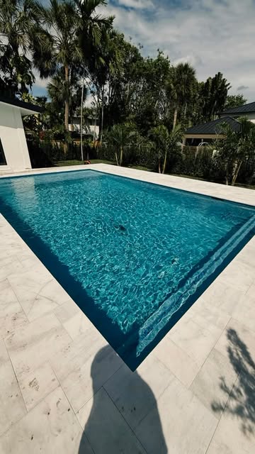 Travertine paver pool deck around rectangular pool