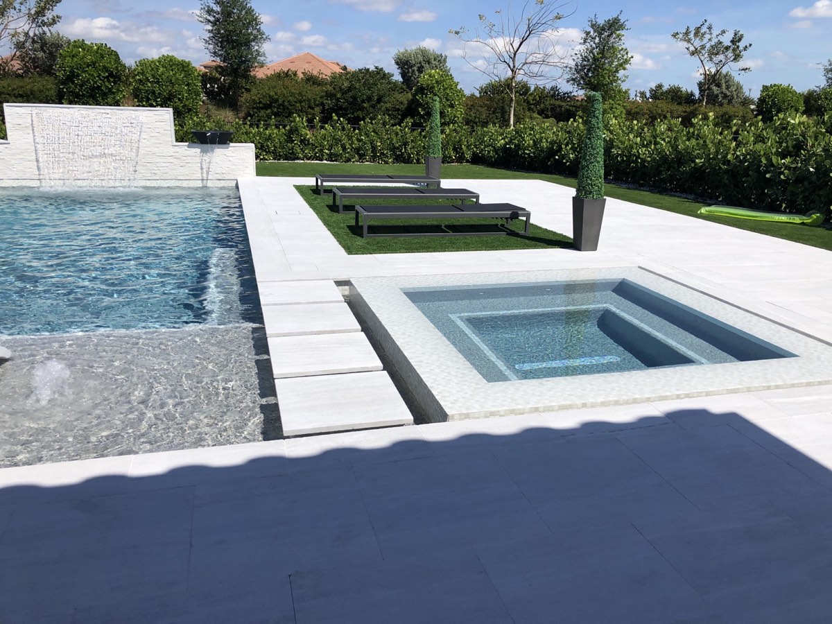 Pool deck with sheer descent waterfall wall and square spa