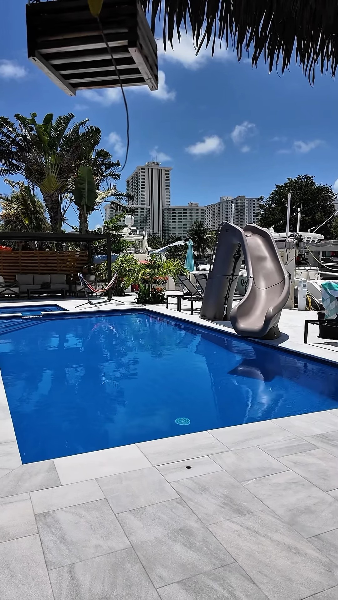Waterfront pool with slide and tiki hut in Fort Lauderdale, FL