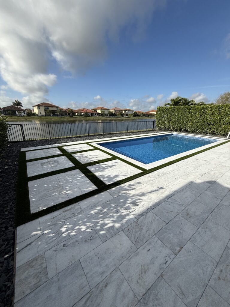 Geometric pool with turf-inlay marble deck, canal-front home in Parkland, FL