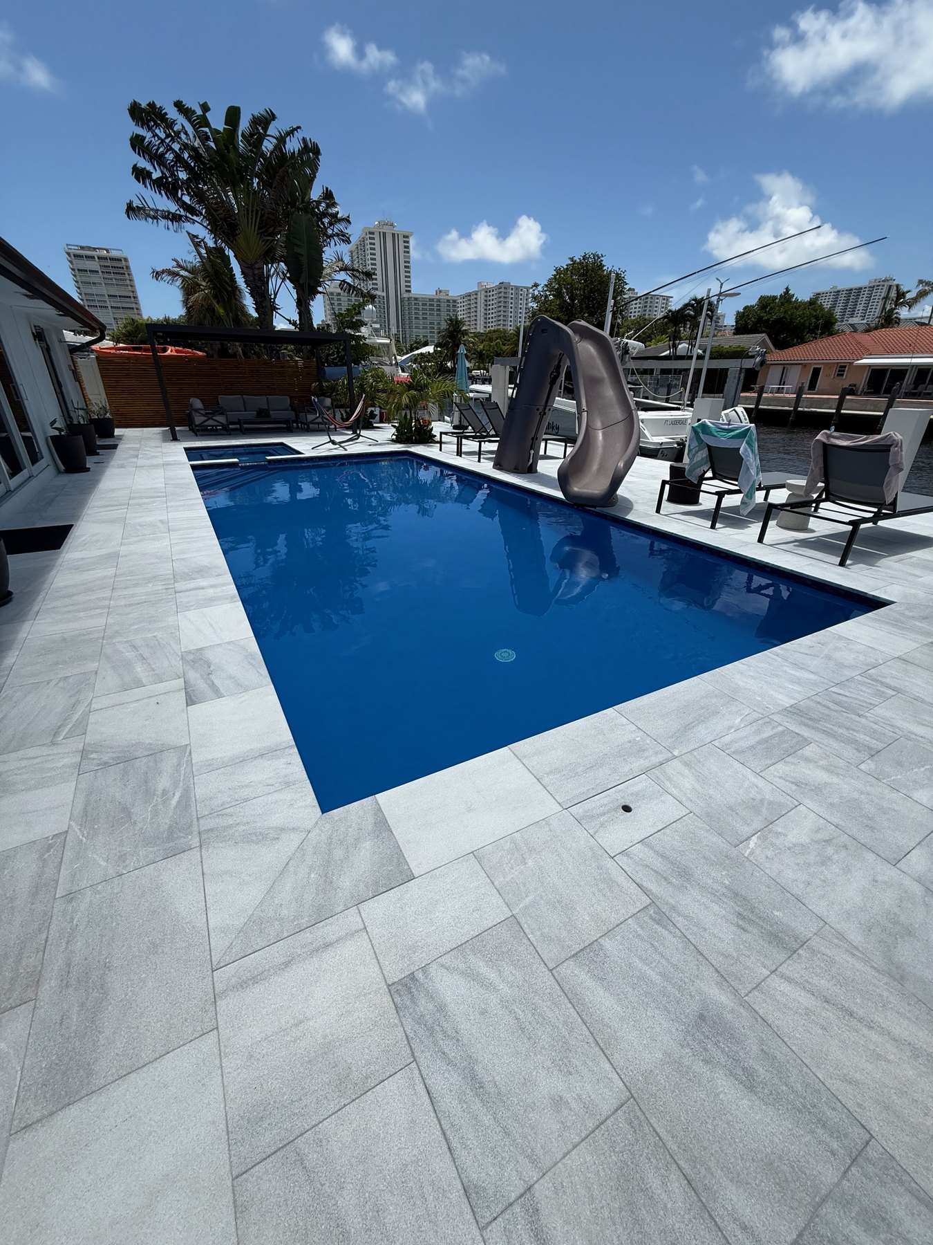 Azure blue pool finish with marble decking on a canal-front home in Fort Lauderdale, Florida