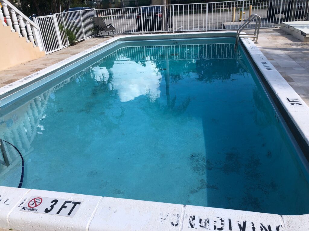 Worn commercial pool interior finish before resurfacing at a Fort Lauderdale multi-family property