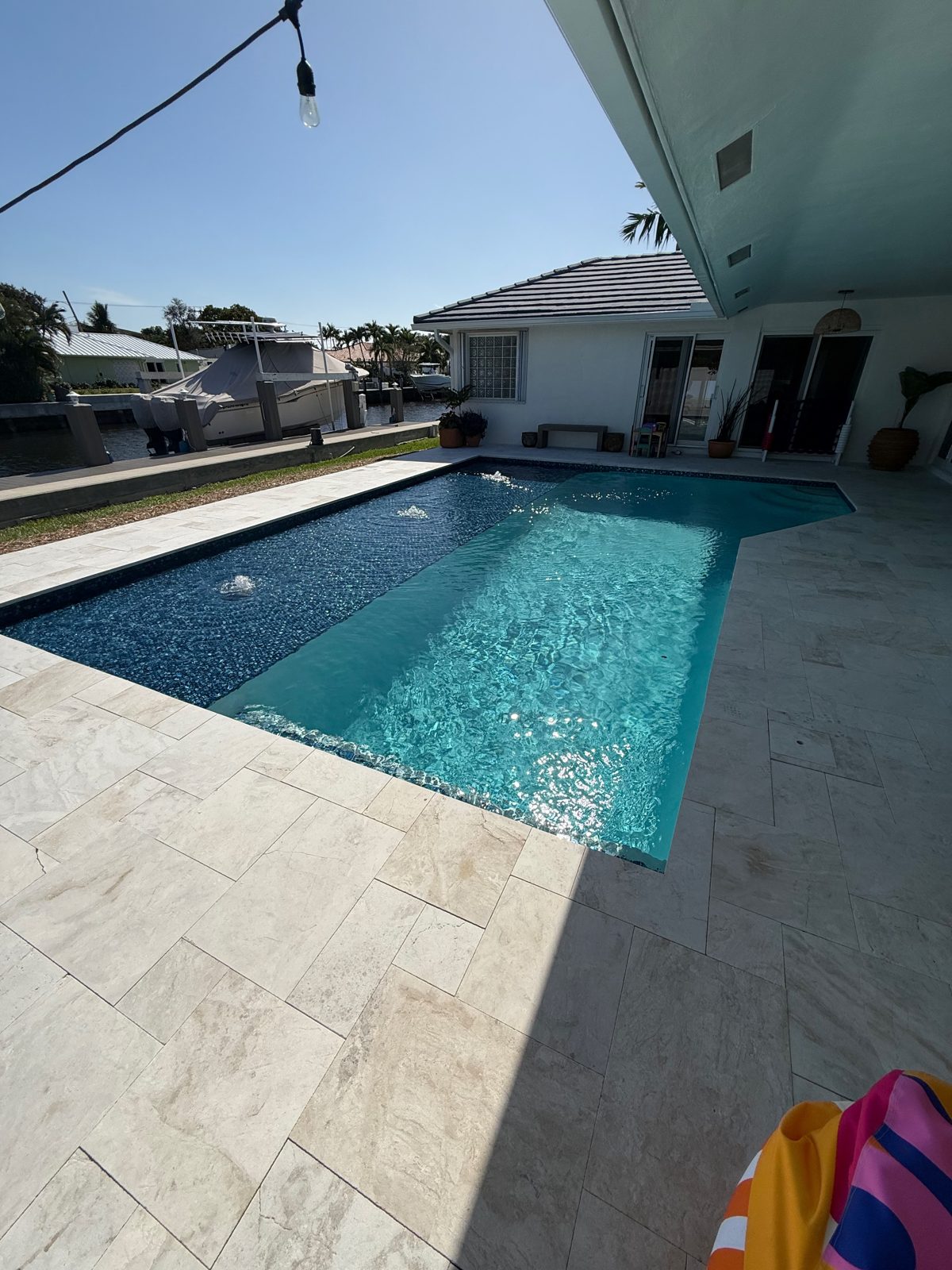 Remodeled waterfront pool with squared corners, sun shelf and marble deck in Fort Lauderdale