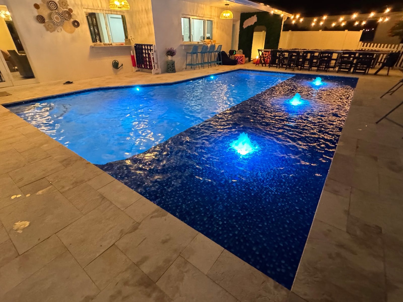 Remodeled Fort Lauderdale pool at night with LED bubblers on the tiled sun shelf