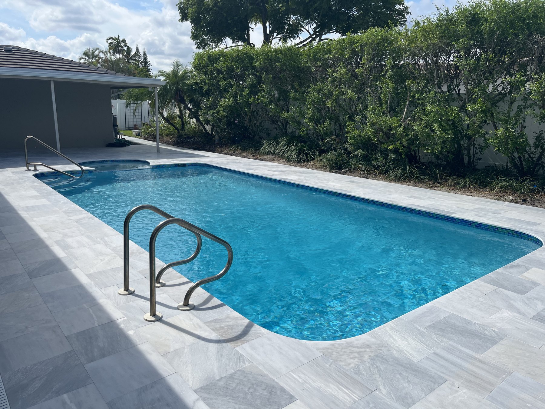 Marble pool decking around a pool and spa at a home in Hollywood, Florida