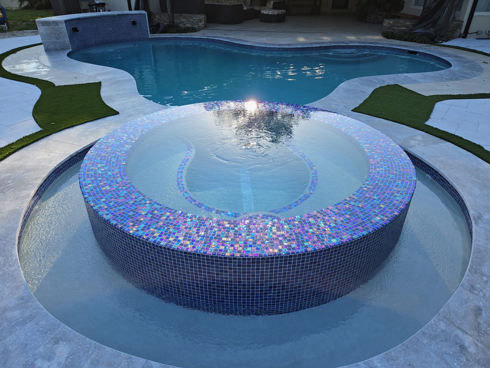 Custom radius spa with mosaic tile and an LED sheer descent water feature in Plantation, Florida